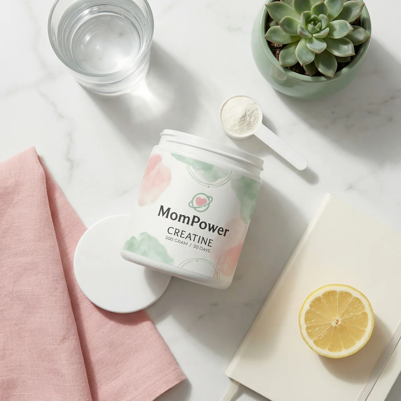 A MomPower jar in a flat lay with pink linen, a lemon, a notebook and a succulent